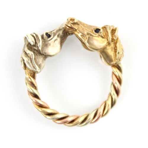 216 - A 9ct yellow gold two tone dress ring, the ring designed as two horses head terminals with twisted s... 