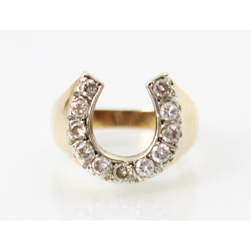 220 - A diamond set yellow metal dress ring, the white metal set round cut diamonds in a horseshoe design,... 