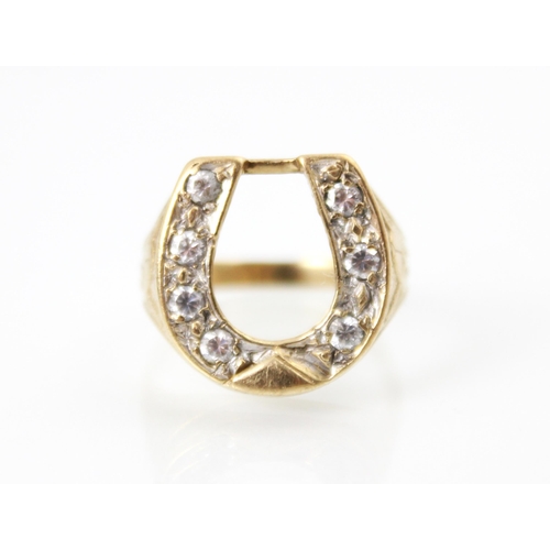 221 - A 9ct yellow gold diamond set dress ring, the raised head designed as a horseshoe with seven round c... 