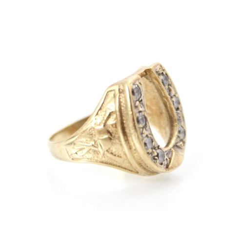 221 - A 9ct yellow gold diamond set dress ring, the raised head designed as a horseshoe with seven round c... 