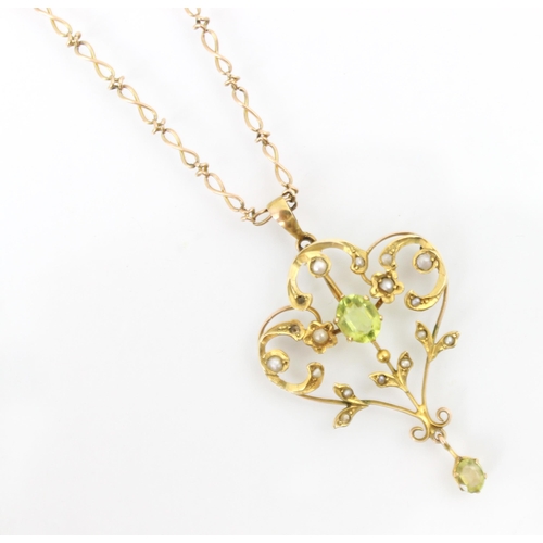 226 - An Edwardian peridot coloured pendant, the oval cut stone set within a sinuous designed openwork mou... 