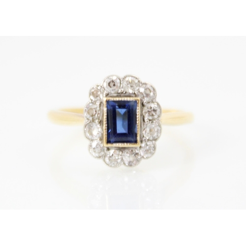 241 - An early 20th century untested sapphire and diamond cluster ring, the rectangular cut sapphire in ye... 