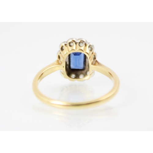 241 - An early 20th century untested sapphire and diamond cluster ring, the rectangular cut sapphire in ye... 