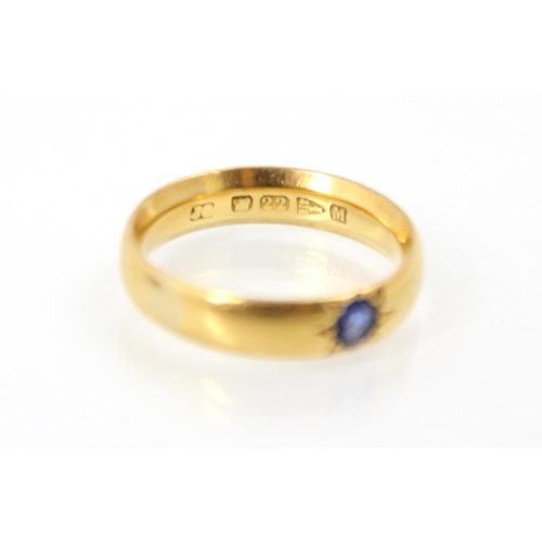 250 - A 22ct yellow gold wedding band, with a round cut untested sapphire later set into the band, ring si... 