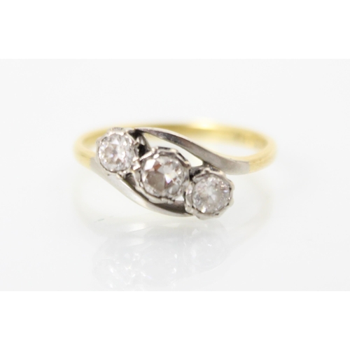 258 - A mid 20th century three stone diamond ring, the central round cut diamond set with smaller round cu... 