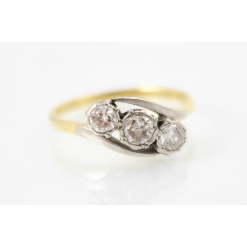 258 - A mid 20th century three stone diamond ring, the central round cut diamond set with smaller round cu... 