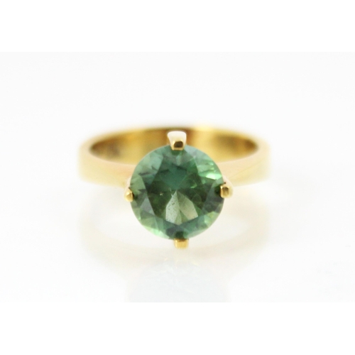 270 - A yellow metal and green tourmaline set dress ring, the round cut tourmaline set in high four claw s... 