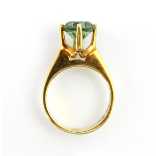 270 - A yellow metal and green tourmaline set dress ring, the round cut tourmaline set in high four claw s... 