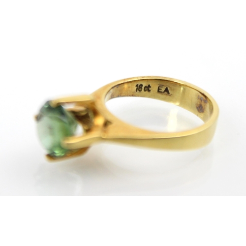 270 - A yellow metal and green tourmaline set dress ring, the round cut tourmaline set in high four claw s... 