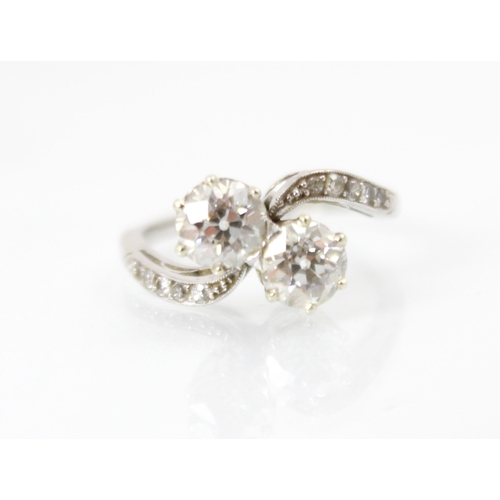 271 - An early 20th century diamond 'toi et moi' ring, the two old cut diamonds claw set in white metal wi... 