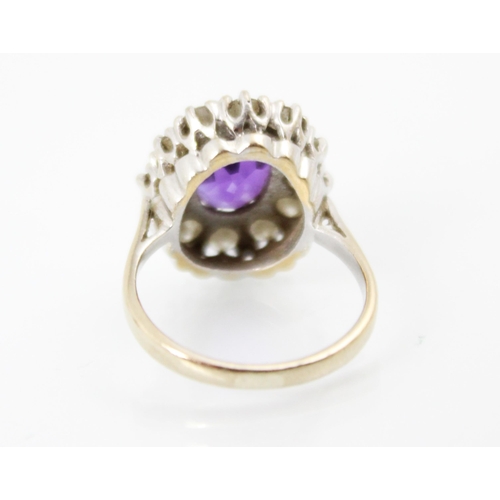 272 - An amethyst and diamond cluster ring, the oval cut amethyst within a surround of twelve round cut di... 