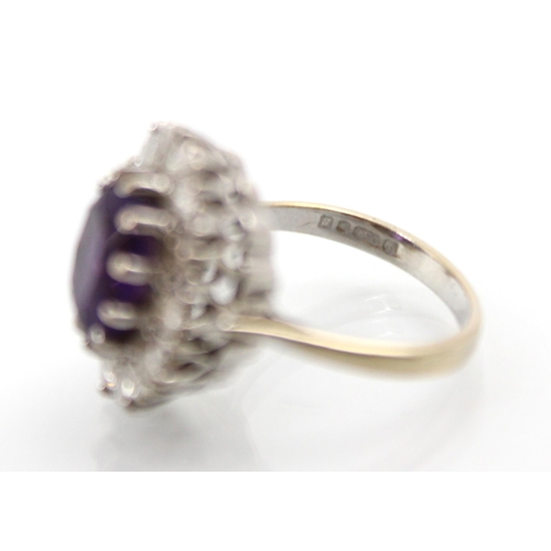 272 - An amethyst and diamond cluster ring, the oval cut amethyst within a surround of twelve round cut di... 