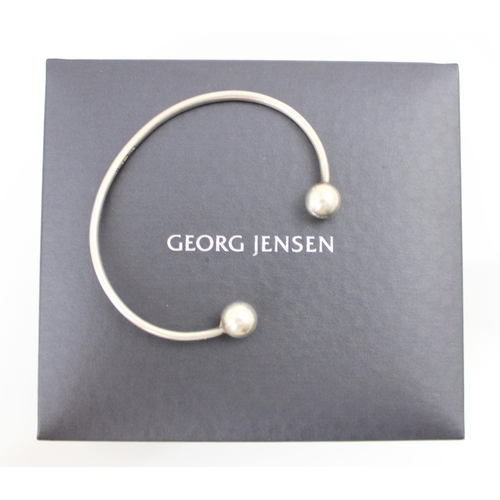 296 - A Georg Jensen torque bangle, of plain polished form with spherical detail to terminals, stamped to ... 