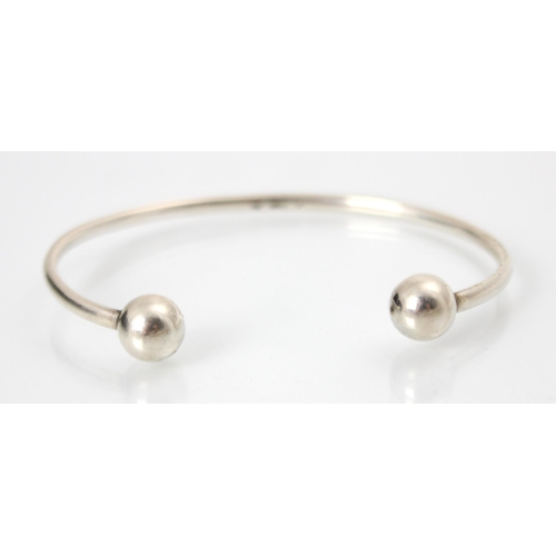 296 - A Georg Jensen torque bangle, of plain polished form with spherical detail to terminals, stamped to ... 