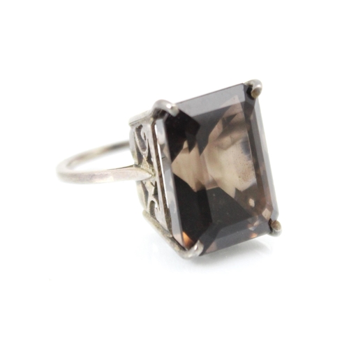 302 - A smokey quartz dress ring, the rectangular cut quartz claw set in silver coloured metal leading to ... 