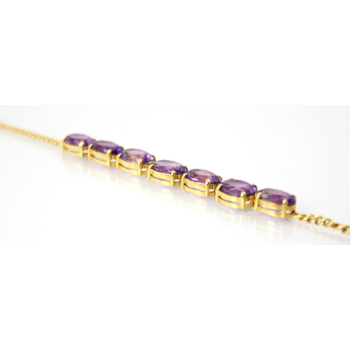 303 - An amethyst set yellow metal bracelet, the seven oval cut amethysts in a four claw setting edge, ope... 