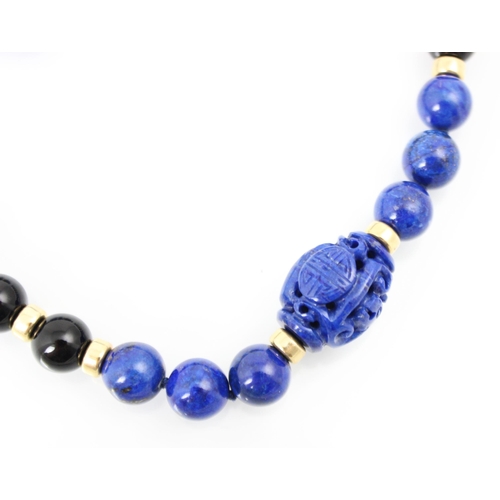 304 - A lapis lazuli and rock crystal necklace, the spherical lapis lazuli beads interspersed with black s... 