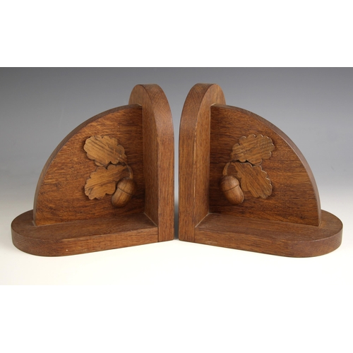 399 - A pair of oak bookends, 20th century, of typical form, each with applied carved oak leaf and acorn m... 