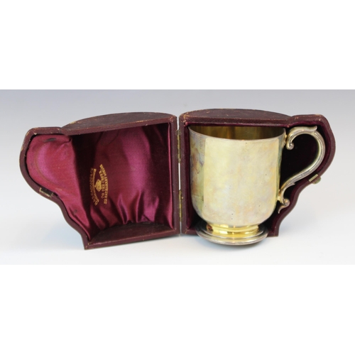 53 - A Victorian silver gilt christening mug, R & S Garrard and Co, London 1865, the scroll handle above ... 