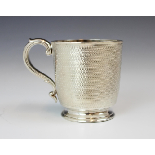 65 - A Victorian silver mug, R and S Garrard & Co, London 1867, the scroll handle above an engine turned ... 