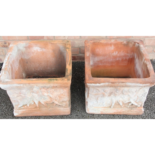 903 - A pair of terracotta planters, of cubic form, each side moulded in relief with classical putti figur... 