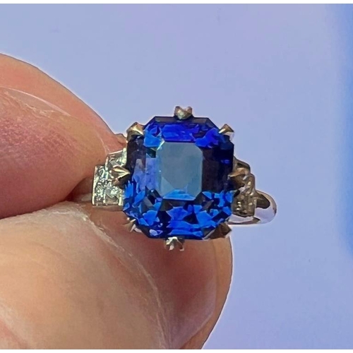 291 - An early 20th century sapphire and diamond ring, the emerald cut sapphire within white metal eight c... 