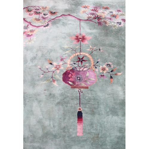 933 - A very large Chinese wool carpet, the central green field adorned with exotic birds upon flowering b... 