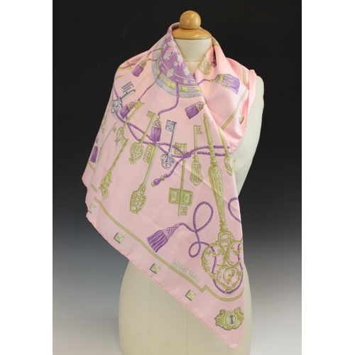 433 - An Hermes silk scarf, in the 'Les Cles' pattern, in pink, lilac and gold tones, with rolled hems, 89... 