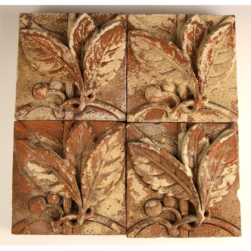 703 - Four high relief moulded terracotta tiles, 19th century, each depicting a leaf and berry sprig, each... 