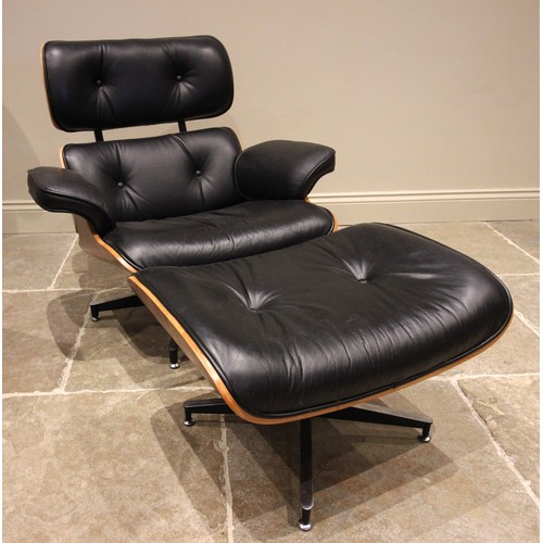 643 - A Charles and Ray Eames style rosewood reclining chair and ottoman, late 20th century, having black ... 