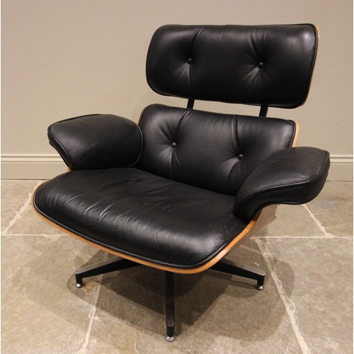 643 - A Charles and Ray Eames style rosewood reclining chair and ottoman, late 20th century, having black ... 