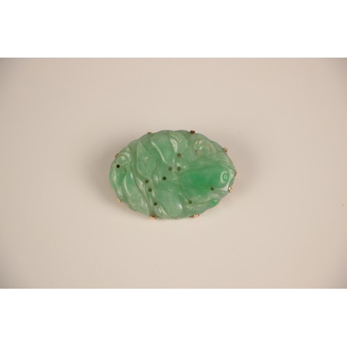 208 - A Birks Ellis ‘jade’ brooch, the carved oval panel with scalloped edge depicting floral detail, with... 