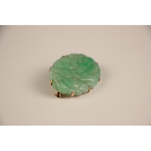 208 - A Birks Ellis ‘jade’ brooch, the carved oval panel with scalloped edge depicting floral detail, with... 