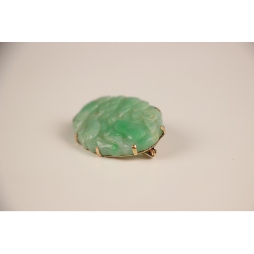 208 - A Birks Ellis ‘jade’ brooch, the carved oval panel with scalloped edge depicting floral detail, with... 