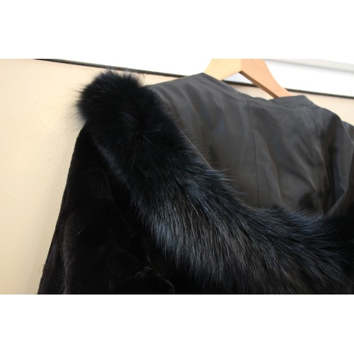 412 - A ladies hooded and reversible mink fur winter long coat, late 20th century, with black fox fur trim... 