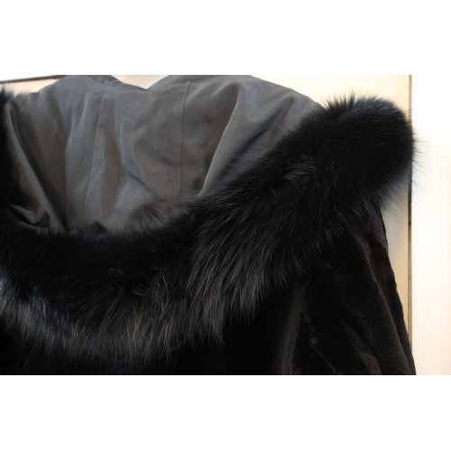 412 - A ladies hooded and reversible mink fur winter long coat, late 20th century, with black fox fur trim... 