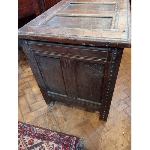 987 - A late 17th/early 18th century carved oak coffer, the four panel cover with hook and eye hinges open... 