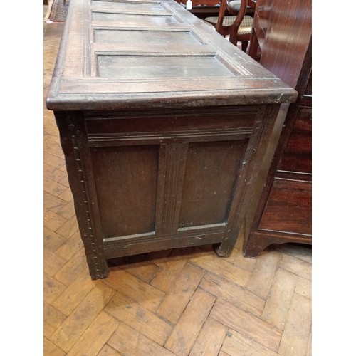 987 - A late 17th/early 18th century carved oak coffer, the four panel cover with hook and eye hinges open... 