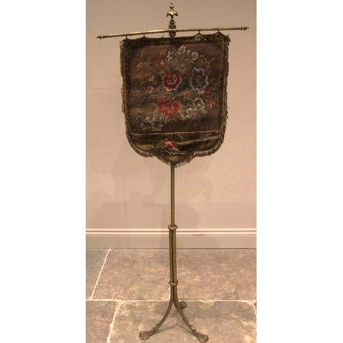 1007 - A Victorian gilt metal pole screen, with a needlework tapestry shield shaped banner screen, upon a c... 