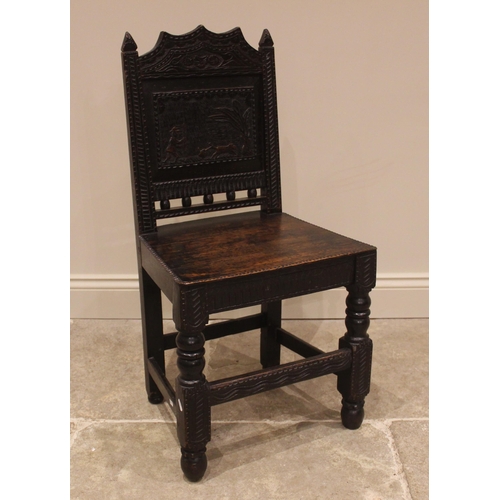 1015 - A 17th century style panel back oak hall chair, 19th century, the back panel carved with a hunting s... 