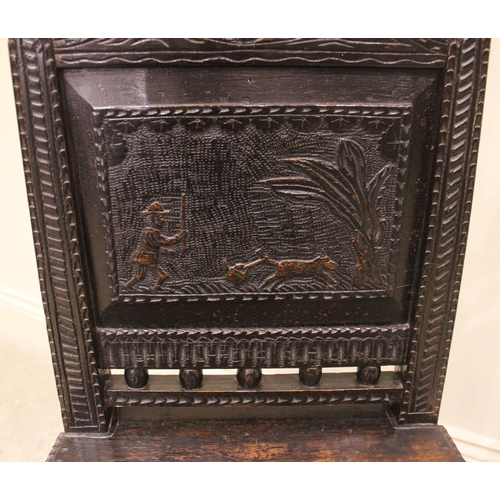 1015 - A 17th century style panel back oak hall chair, 19th century, the back panel carved with a hunting s... 