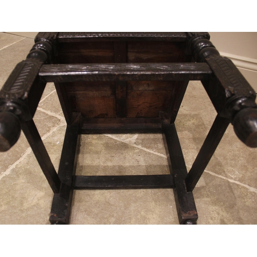 1015 - A 17th century style panel back oak hall chair, 19th century, the back panel carved with a hunting s... 