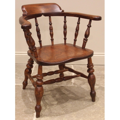 1030 - A Victorian elm and beech smokers bow elbow chair, the horseshoe shaped top rail upon turned baluste... 