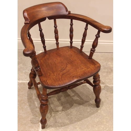 1030 - A Victorian elm and beech smokers bow elbow chair, the horseshoe shaped top rail upon turned baluste... 