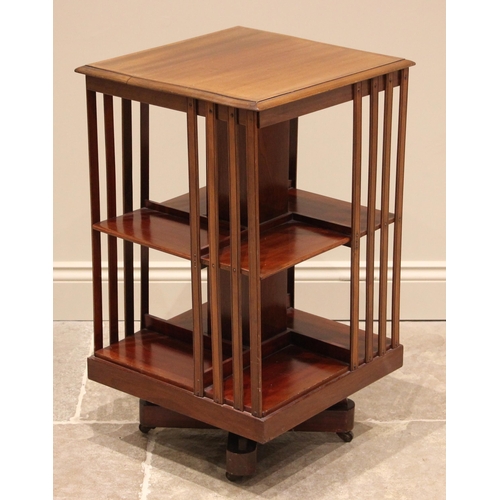 1042 - An Edwardian mahogany revolving bookcase, the moulded square top over twin tiers each with four comp... 