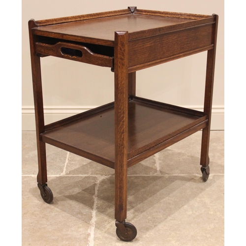 1060 - A vintage 1930’s oak cocktail trolley, the rectangular three quarter galleried upper tier with a rem... 