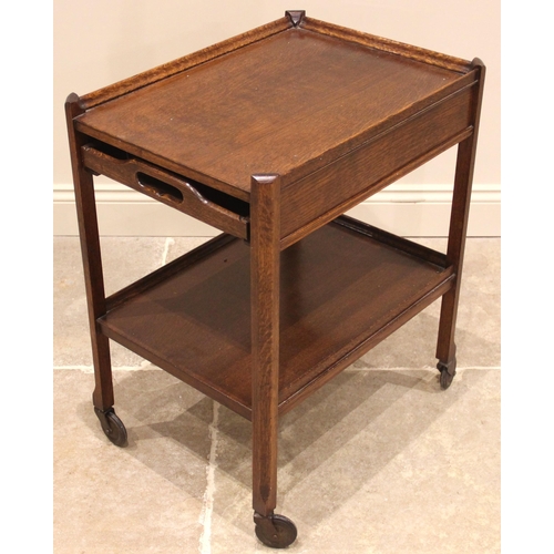 1060 - A vintage 1930’s oak cocktail trolley, the rectangular three quarter galleried upper tier with a rem... 