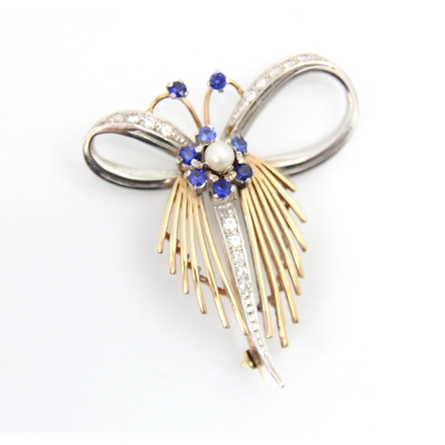 145 - A 9ct white and yellow gold stylised spray brooch, the central flowerhead motif set with blue stones... 