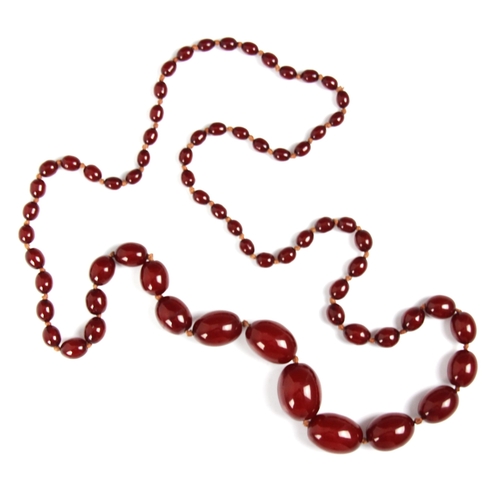 159 - A string of cherry coloured 'amber' beads, the graduated beads strung upon string, largest bead 2.9c... 