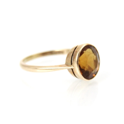 170 - A 20th century citrine set ring, the round cut citrine with a rubover mount leading to plain polishe... 